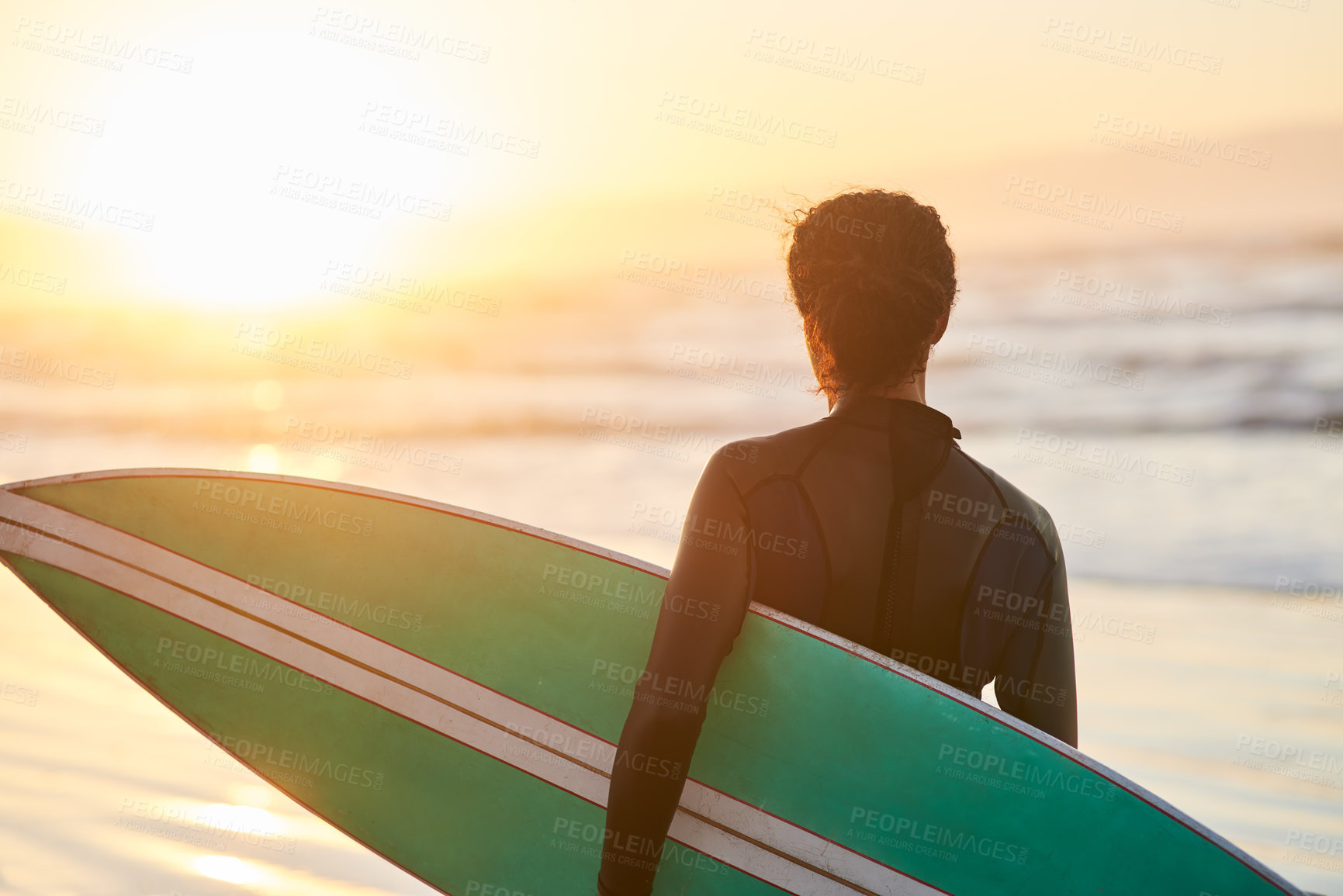 Buy stock photo Sunset, surfboard and back of person at ocean for fitness, exercise and wellness in summer. Wetsuit, athlete and challenge or water sports at beach for adventure, cardio and balance in California