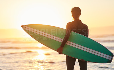 Buy stock photo Rearview shot of a female carrying her surfboard at the beach