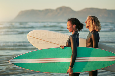 Buy stock photo Shot of a cheerful young couple going surfing at the beach