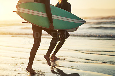 Buy stock photo Shot of an unrecognizable young couple going surfing at the beach
