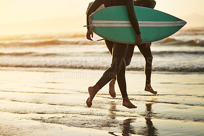 Buy stock photo Shot of an unrecognizable young couple going surfing at the beach