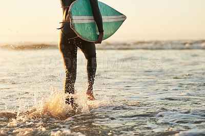 Buy stock photo Rearview shot of an unrecognizable young woman going surfing at the beach