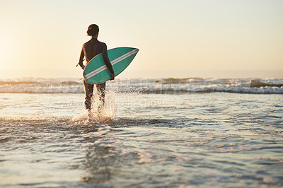Buy stock photo Rearview shot of a young woman going surfing at the beach