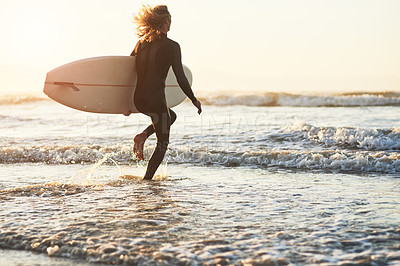 Buy stock photo Rearview shot of a young man surfing at the beach