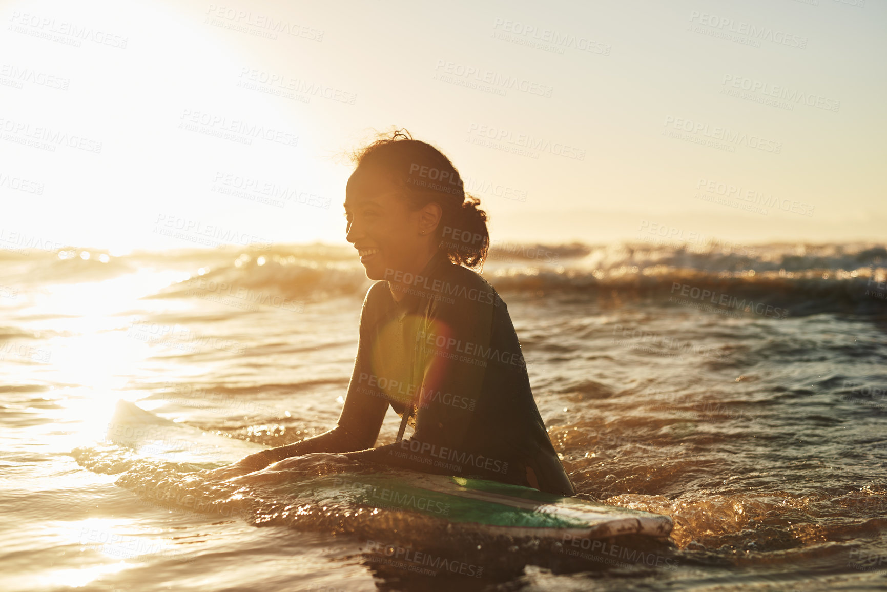 Buy stock photo Surfer, woman and swimming in ocean with wetsuit for summer adventure, sunset and fun activity in water. Girl, surfing sport and floating in waves with board for vacation travel, exercise and peace