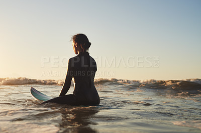 Buy stock photo Rearview shot of a young woman surfing in the ocean