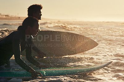 Buy stock photo Shot of two young surfers surfing together in the ocean