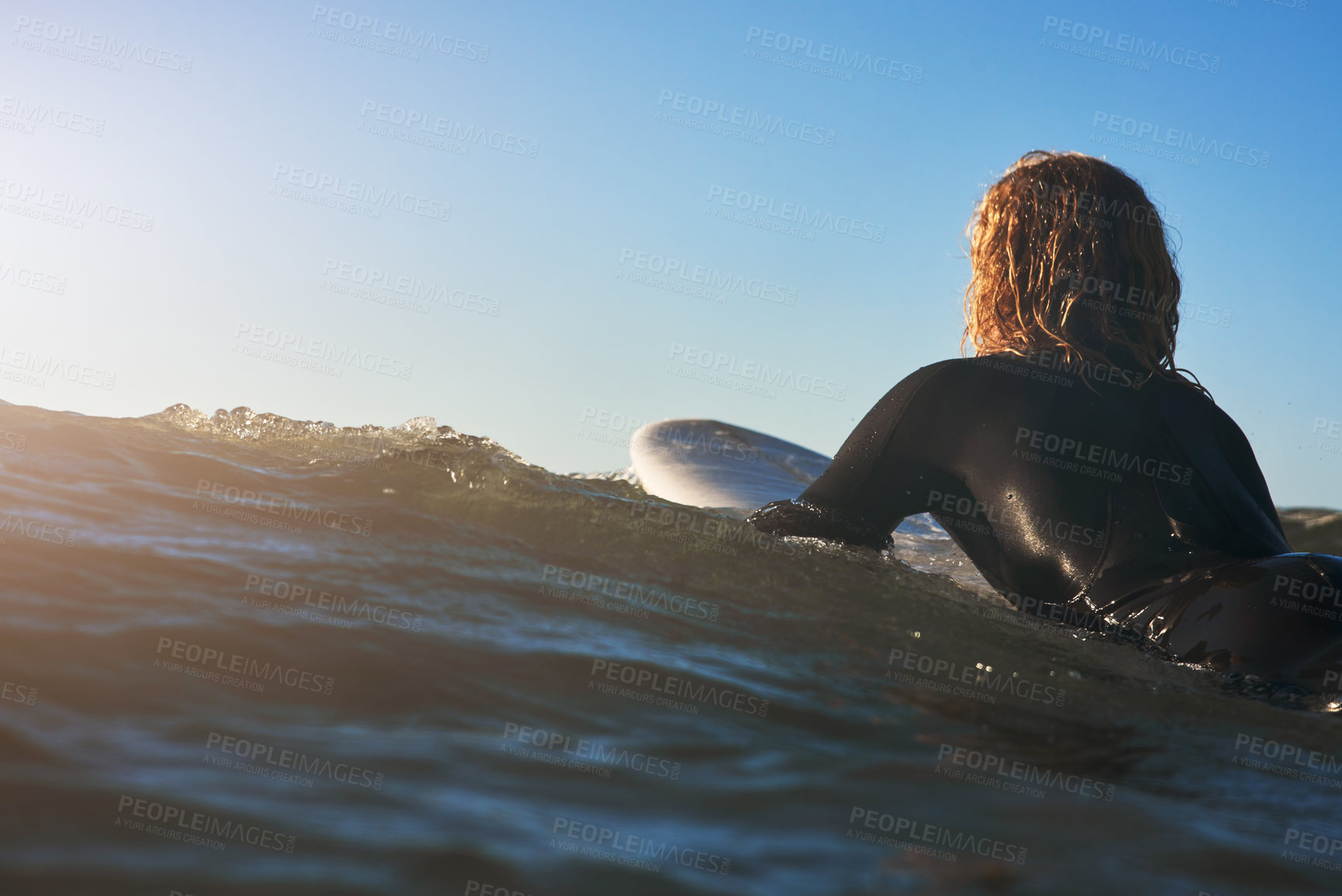 Buy stock photo Rearview shot of a young man surfing in the ocean