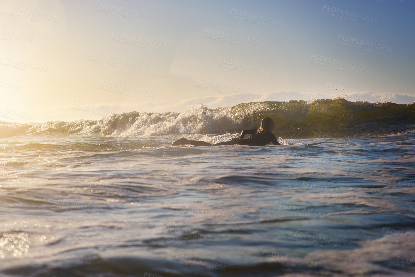 Buy stock photo Rearview shot of a young man surfing in the ocean