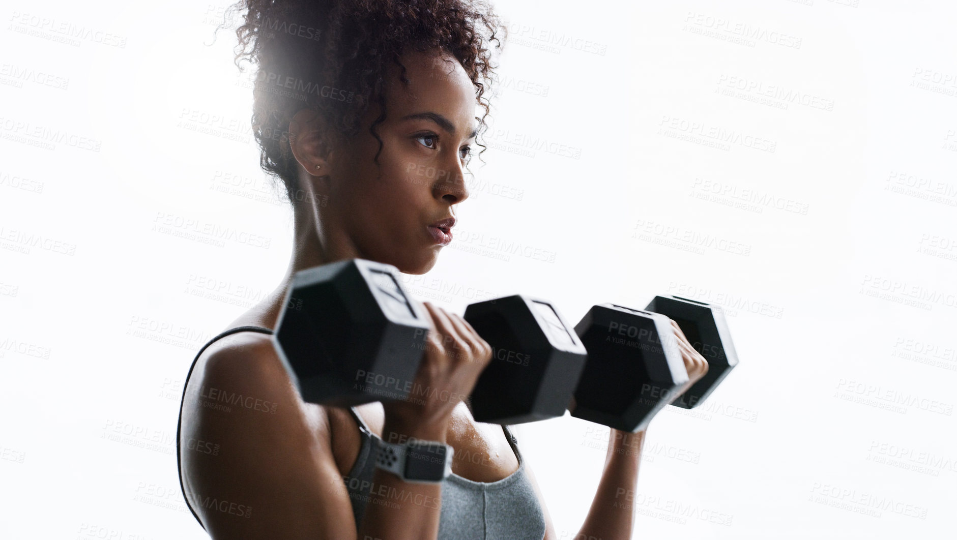 Buy stock photo Shot of a young woman working out with dumbbells in a gym