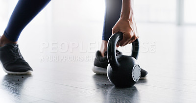 Buy stock photo Cropped shot of a woman working out with kettlebells in a gym