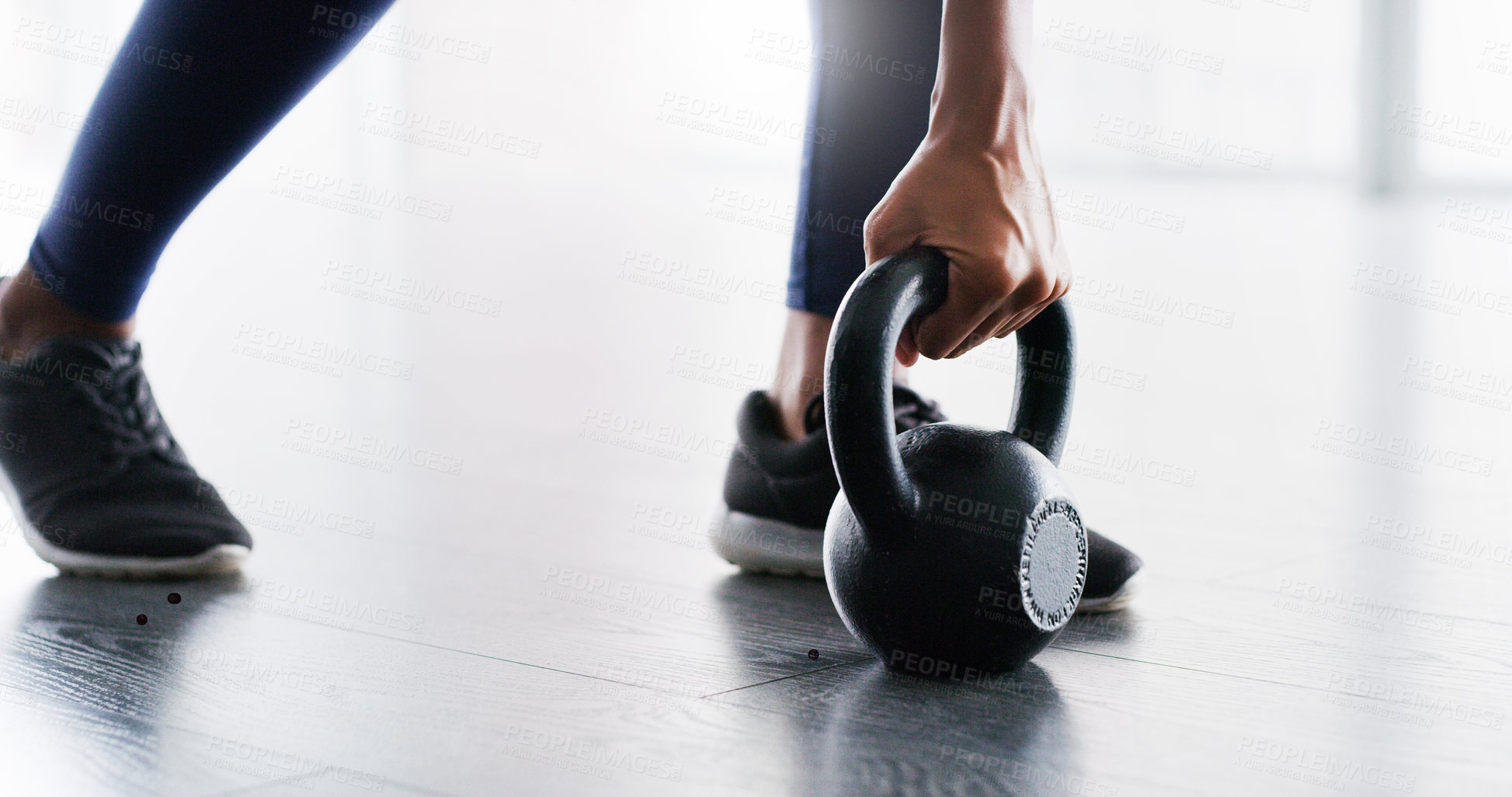 Buy stock photo Cropped shot of a woman working out with kettlebells in a gym