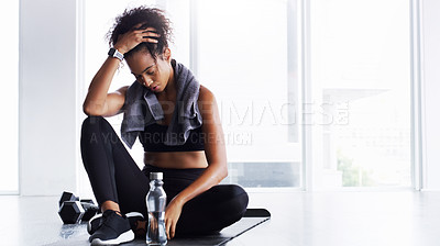Buy stock photo Shot of a young woman taking a break from her workout in a gym