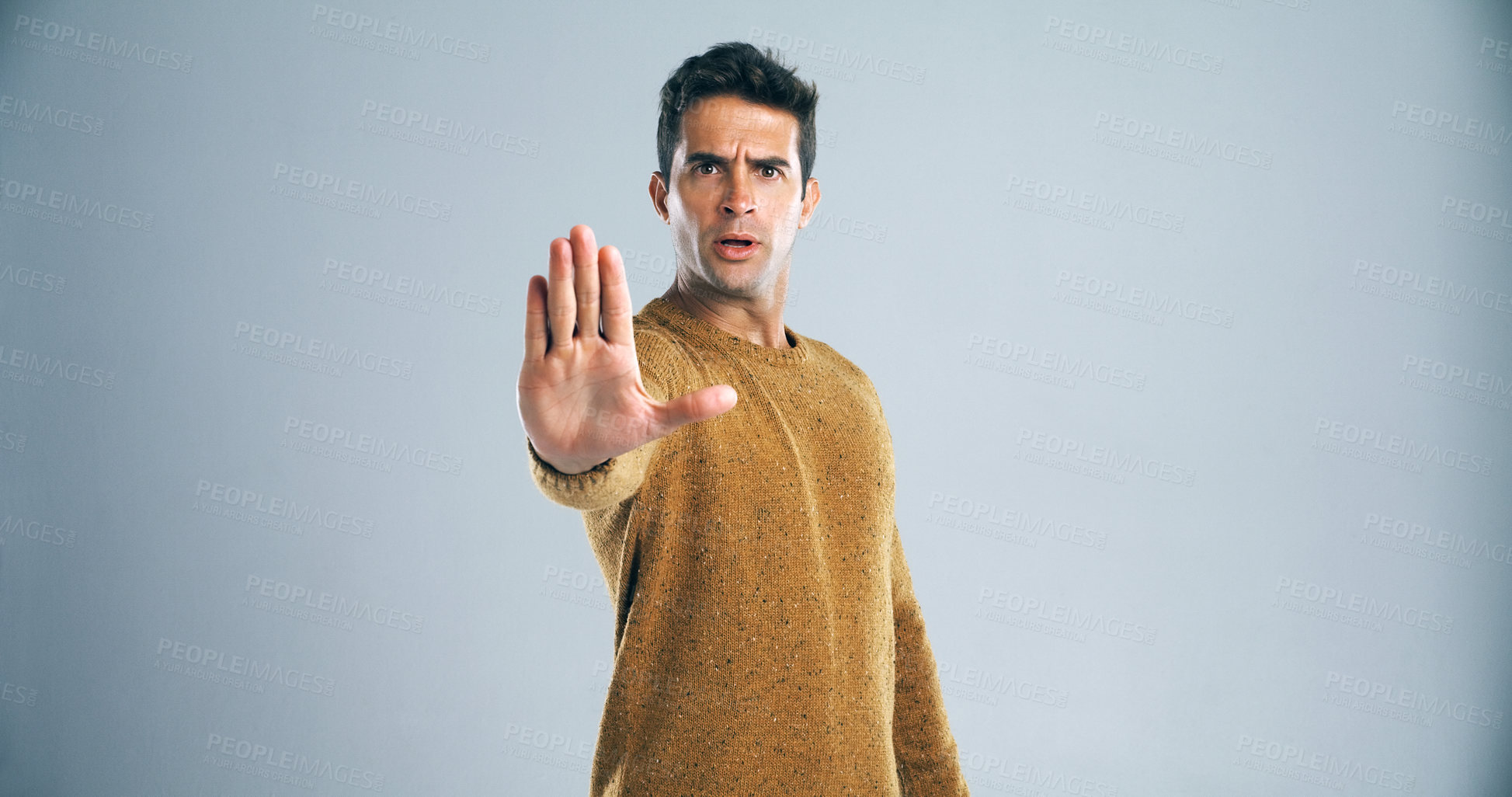 Buy stock photo Studio shot of a handsome young man gesturing to stop against a gray background