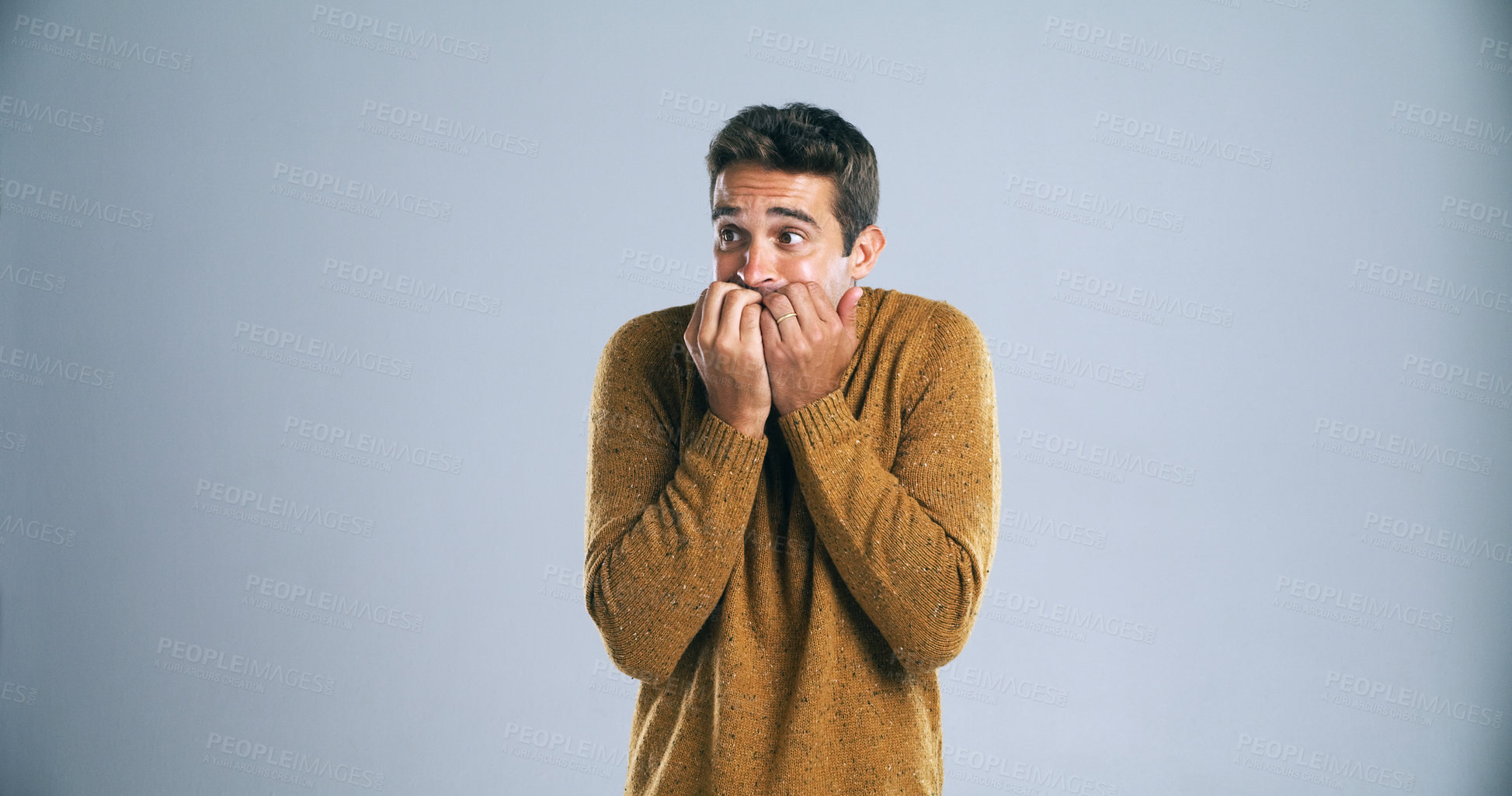 Buy stock photo Scared, man and biting nails with fear in studio for horror, terror and panic for danger on mockup space. Worried person, nervous or suspense with surprise, overwhelmed or bad news on gray background