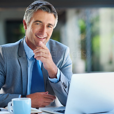 Buy stock photo Cropped portrait of a handsome mature businessman looking confident while working on a laptop outdoors