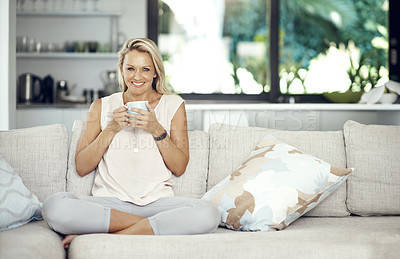 Buy stock photo Full length portrait of an attractive mature woman enjoying a warm beverage while relaxing on the sofa at home