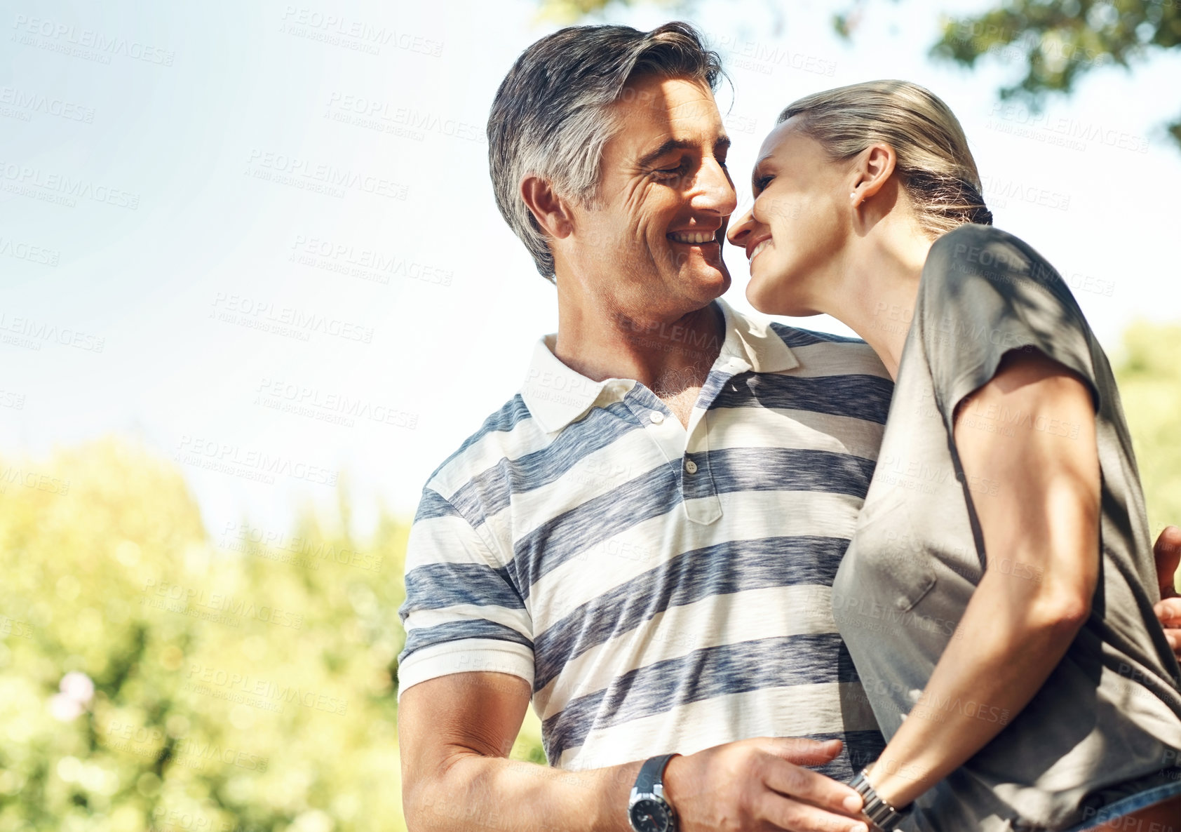 Buy stock photo Hug, love and couple in park walking for bonding, relationship and relax in morning outdoors. Nature, happy and mature man and woman laughing for romance, affection and marriage on weekend together