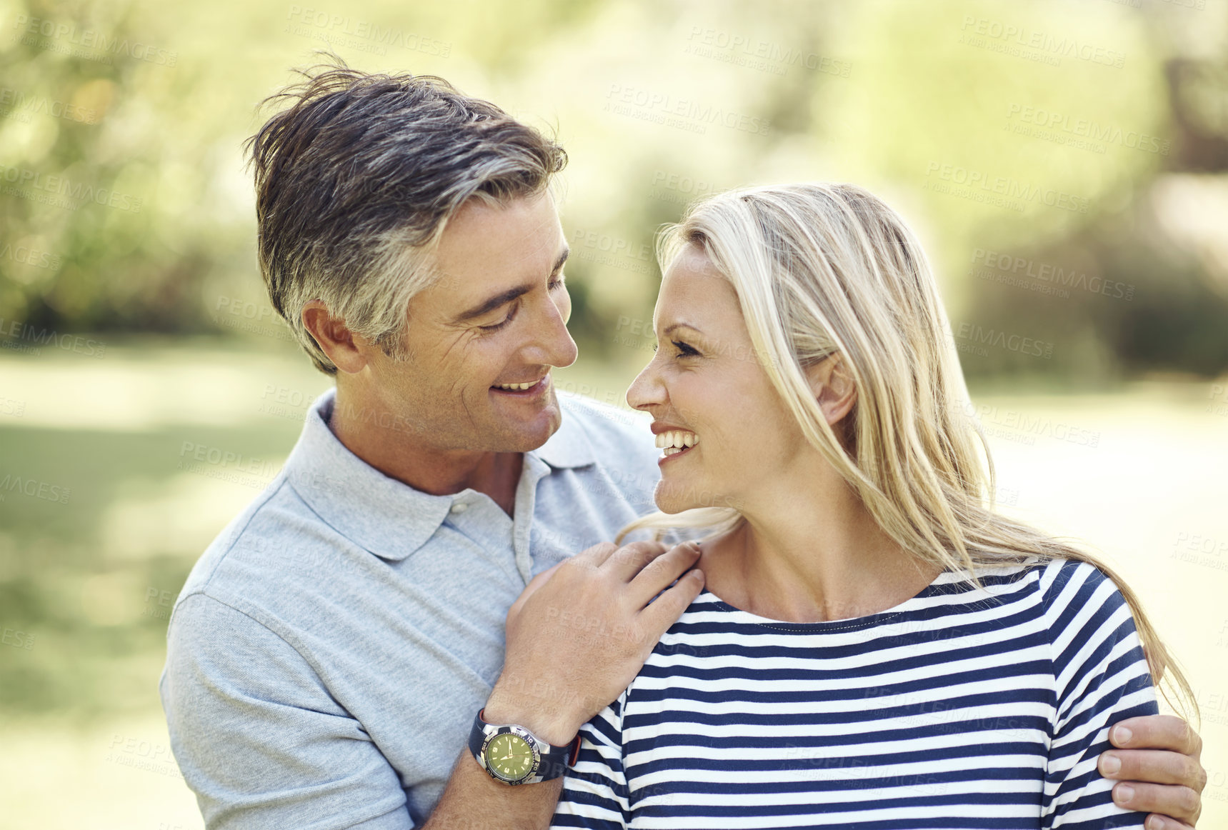 Buy stock photo Cropped shot of an affectionate mature couple enjoying a day in the park