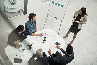 Buy stock photo High angle shot of a businesswoman giving a presentation to colleagues sitting around a table in an office