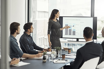 Buy stock photo Cropped shot of a pregnant businesswoman giving a presentation on a monitor to colleagues in an boardroom