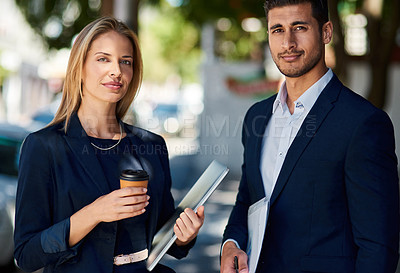 Buy stock photo Cropped portrait of two corporate colleagues standing outside during their morning commute to work
