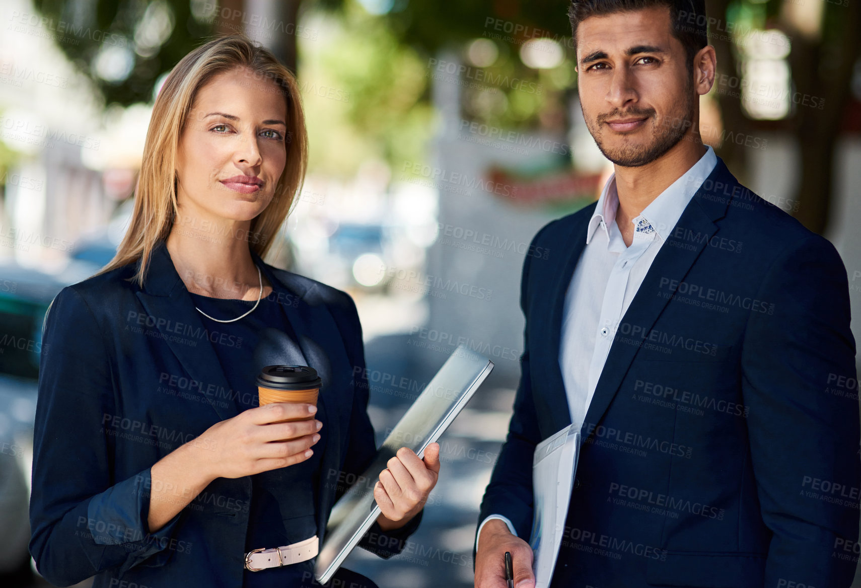 Buy stock photo Cropped portrait of two corporate colleagues standing outside during their morning commute to work