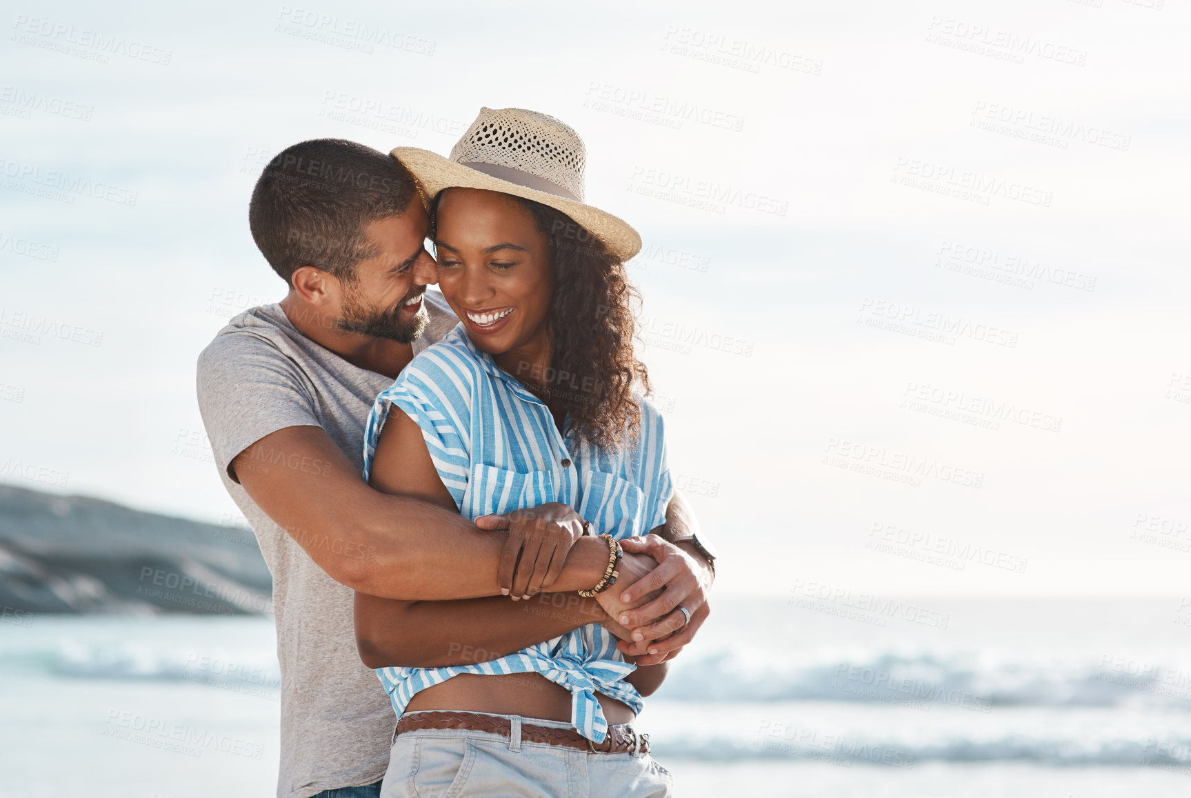 Buy stock photo Love, relaxing and hug with interracial couple, beach and people for anniversary on holiday together. Romance, man and woman with ocean, summer break and relax with sunset mockup space on vacation