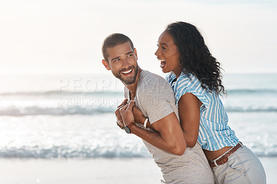 Buy stock photo Shot of a young couple enjoying some quality time together at the beach