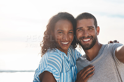 Buy stock photo Portrait of a young couple taking selfies together at the beach