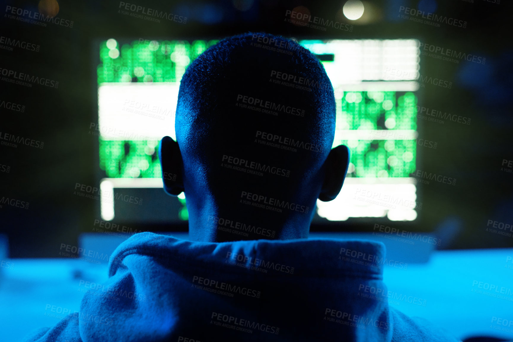 Buy stock photo Rearview shot of a male hacker cracking a computer code in the dark