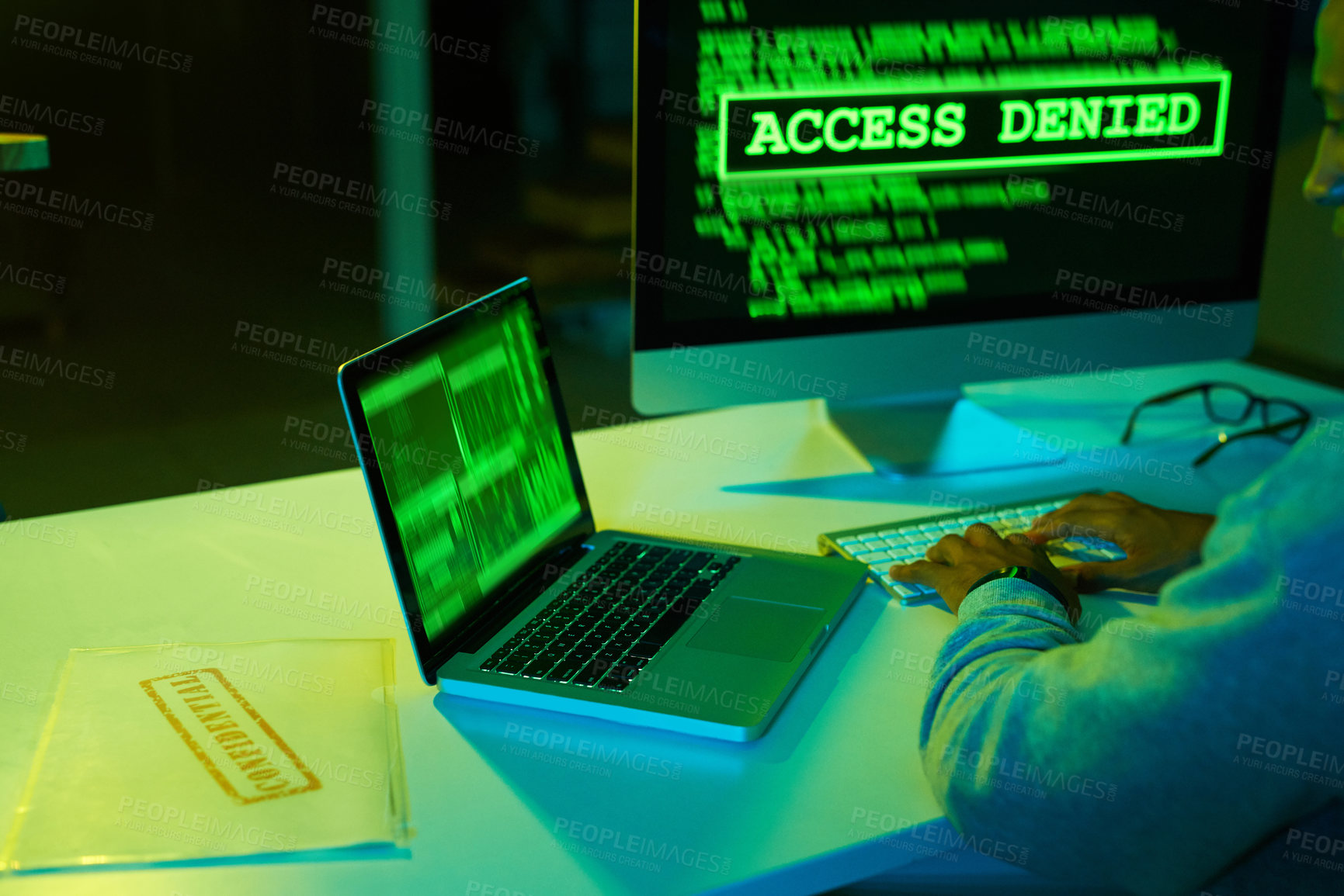 Buy stock photo Shot of an unrecognizable hacker cracking a computer code in the dark