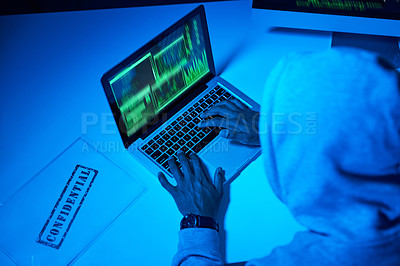 Buy stock photo High angle shot of a young male hacker using a laptop in the dark