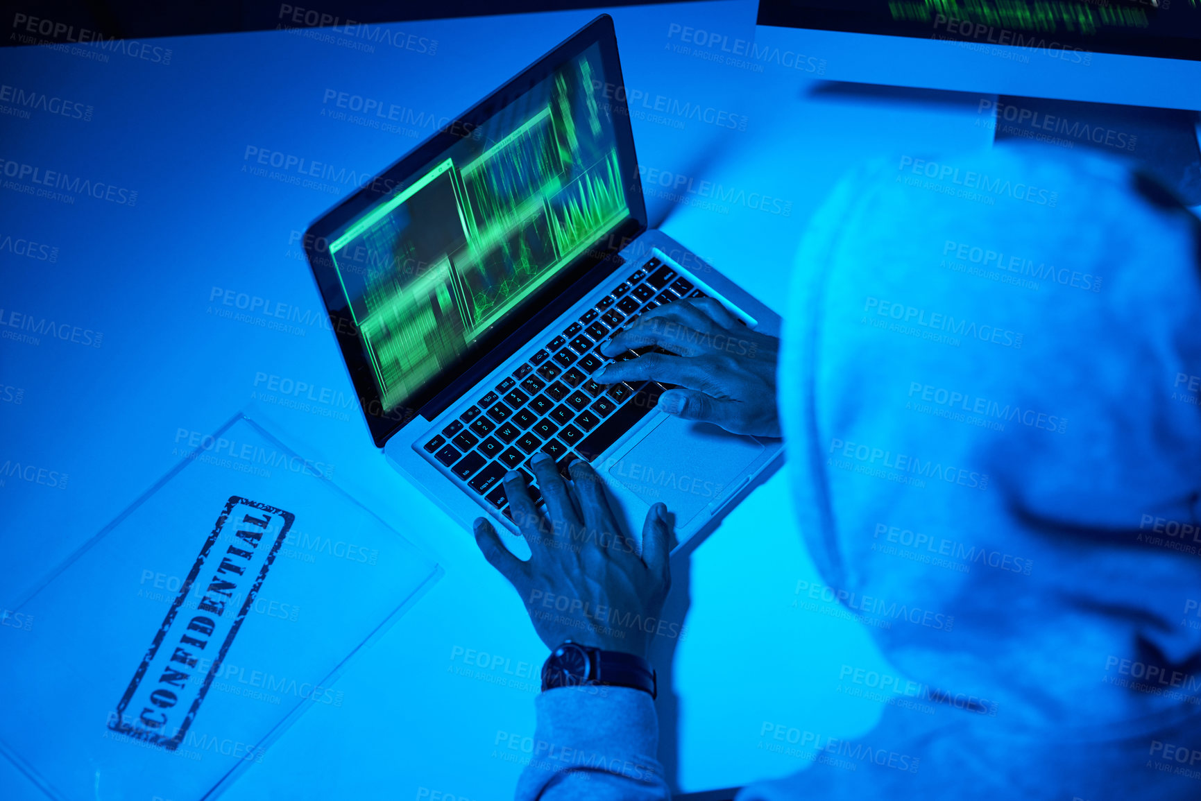 Buy stock photo High angle shot of a young male hacker using a laptop in the dark