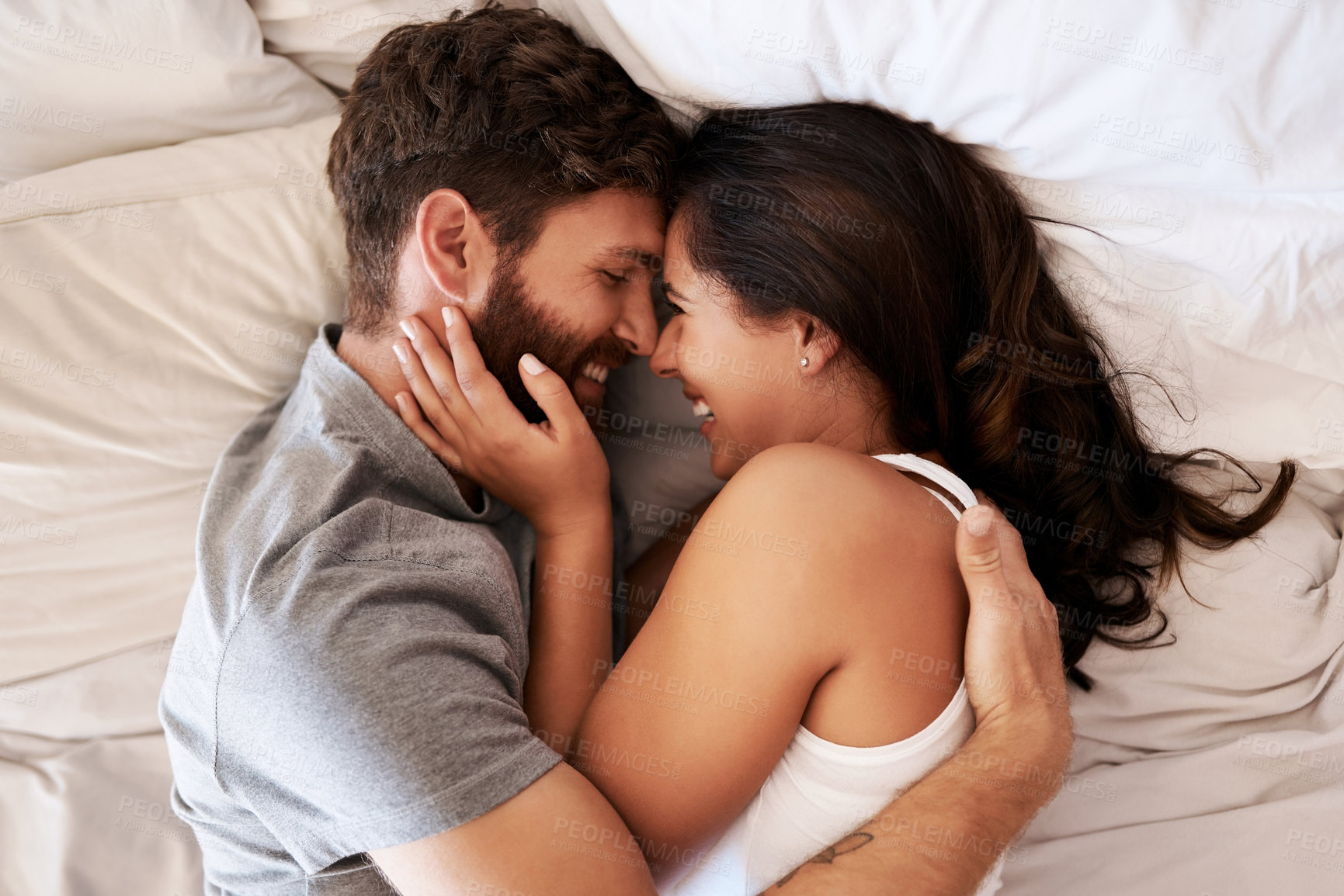 Buy stock photo Smile, bed and happy couple hug, relax and spending lazy morning together, bonding and intimacy on Spain vacation. Happiness, marriage and top view of romantic man, woman or people embrace in bedroom