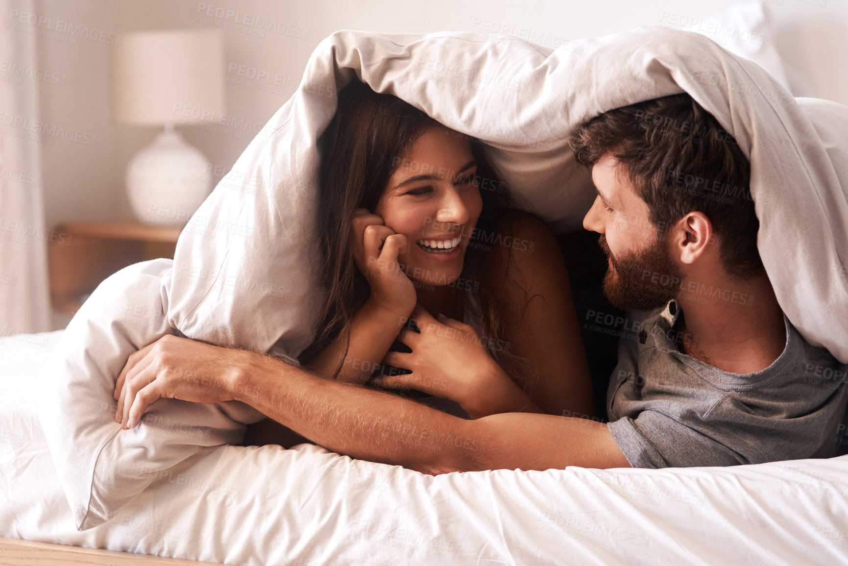 Buy stock photo Blanket, relax and couple with love, home and comfortable with joy, romance and loving together. Partners, man and happy woman in the bedroom, happiness and peace with a smile, romantic and bonding 