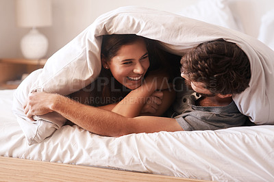 Buy stock photo Blanket, smile and couple with love, home and peace with happiness, romance and loving together. Partners, man and woman in the bedroom, peace and romantic with peace, laughing and bonding at home