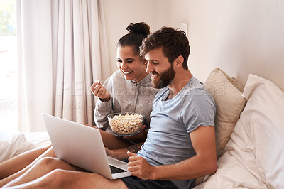 Buy stock photo Watching movie, popcorn and couple in bed with laptop for streaming, food and internet. Subscription, happy and comic with man and woman at home for social media, funny and free time on weekend