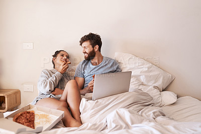 Buy stock photo Couple laugh, pizza and movie on laptop in bed with junk food and streaming series. Eating, computer video and meal in a bedroom at home with man and woman together with bonding and online watching