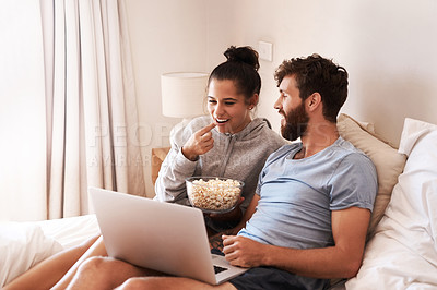 Buy stock photo Laptop, watching movie and popcorn with couple in bed for streaming, relax or internet. Subscription, happy and love with man and woman eating at home for social media, funny and free time on weekend
