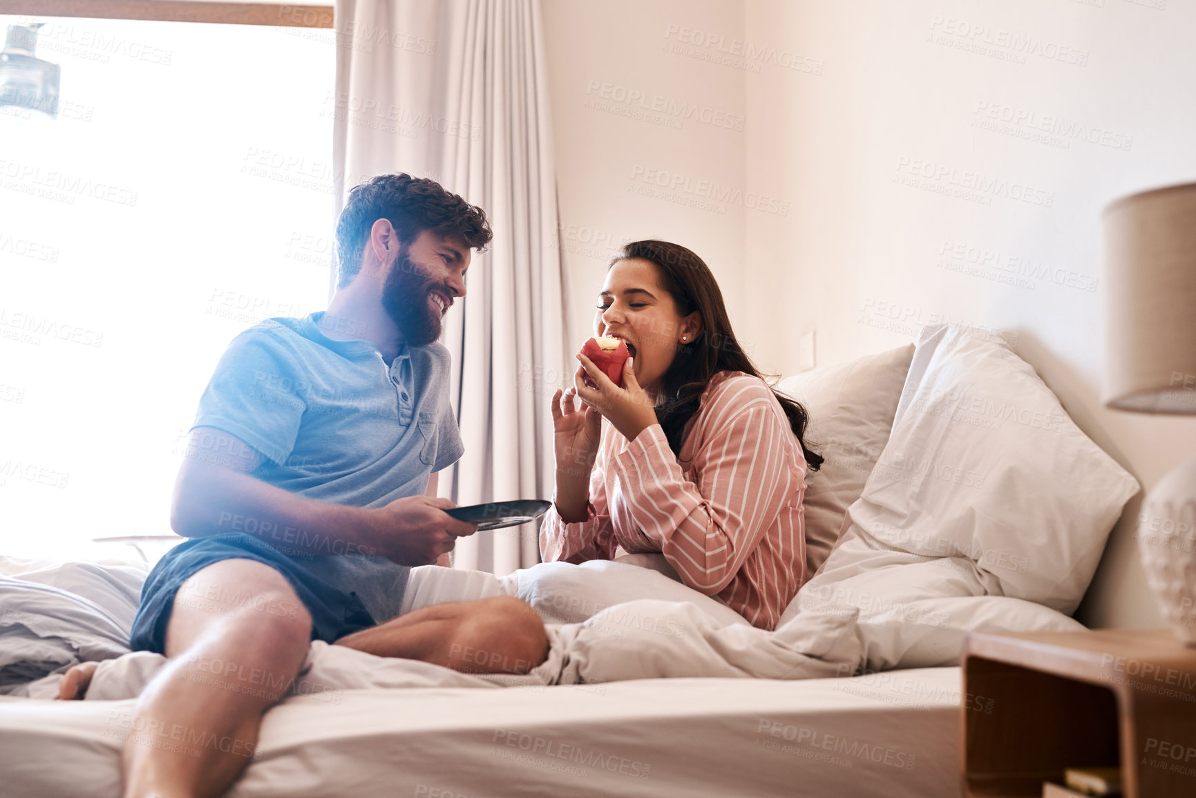 Buy stock photo Couple, bedroom and eating birthday cupcake, surprise candy dessert or celebration sweets on Italy holiday. Breakfast muffin, morning food or woman hungry, relax and celebrate special day on home bed