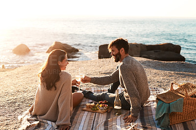 Buy stock photo Picnic, beach and couple with champagne happy for relax, bonding and quality time on romantic date. Nature, dating and man and woman toast for anniversary, honeymoon and love on holiday or vacation