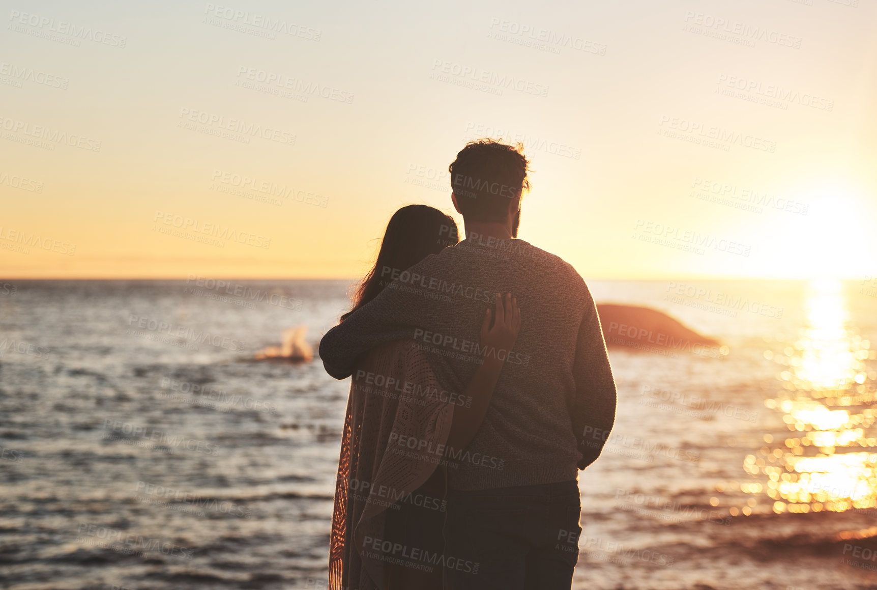 Buy stock photo Sunset, beach and couple hug by ocean in evening on holiday, summer vacation and weekend. Nature, love and man and woman embrace, hugging and relax for bonding, quality time and peace in evening