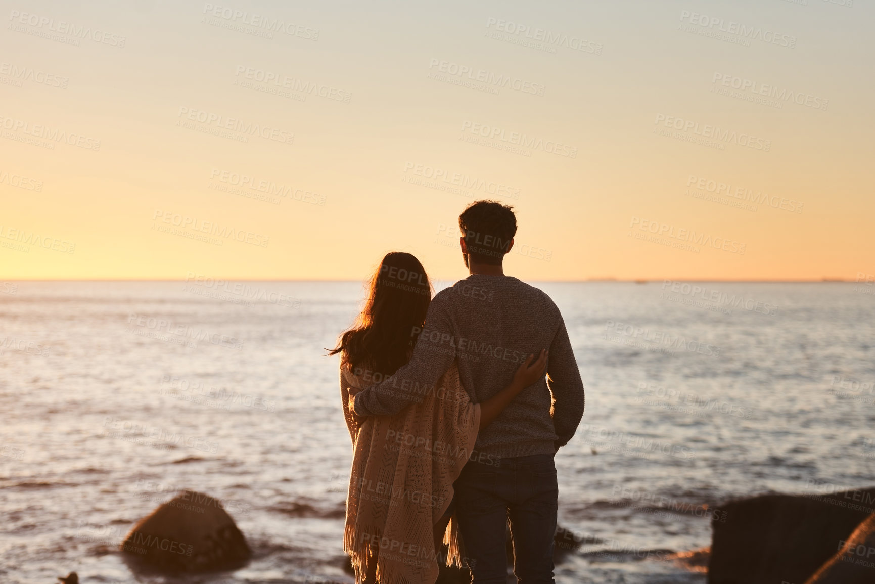 Buy stock photo Hug, sunset and couple relax on beach in evening on holiday, summer vacation and weekend by ocean. Nature, love and man and woman embrace, hugging and calm for bonding, quality time and peace by sea