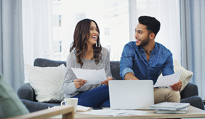 Buy stock photo Cropped shot of a happy young couple sitting on the sofa while going through paperwork in their lounge