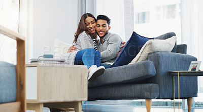 Buy stock photo Cropped portrait of an affectionate young couple cuddling with each other while in their living room during the day