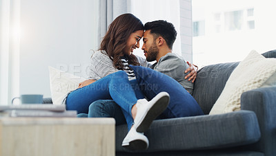 Buy stock photo Cropped shot of an affectionate young couple cuddling with each other while in their living room during the day