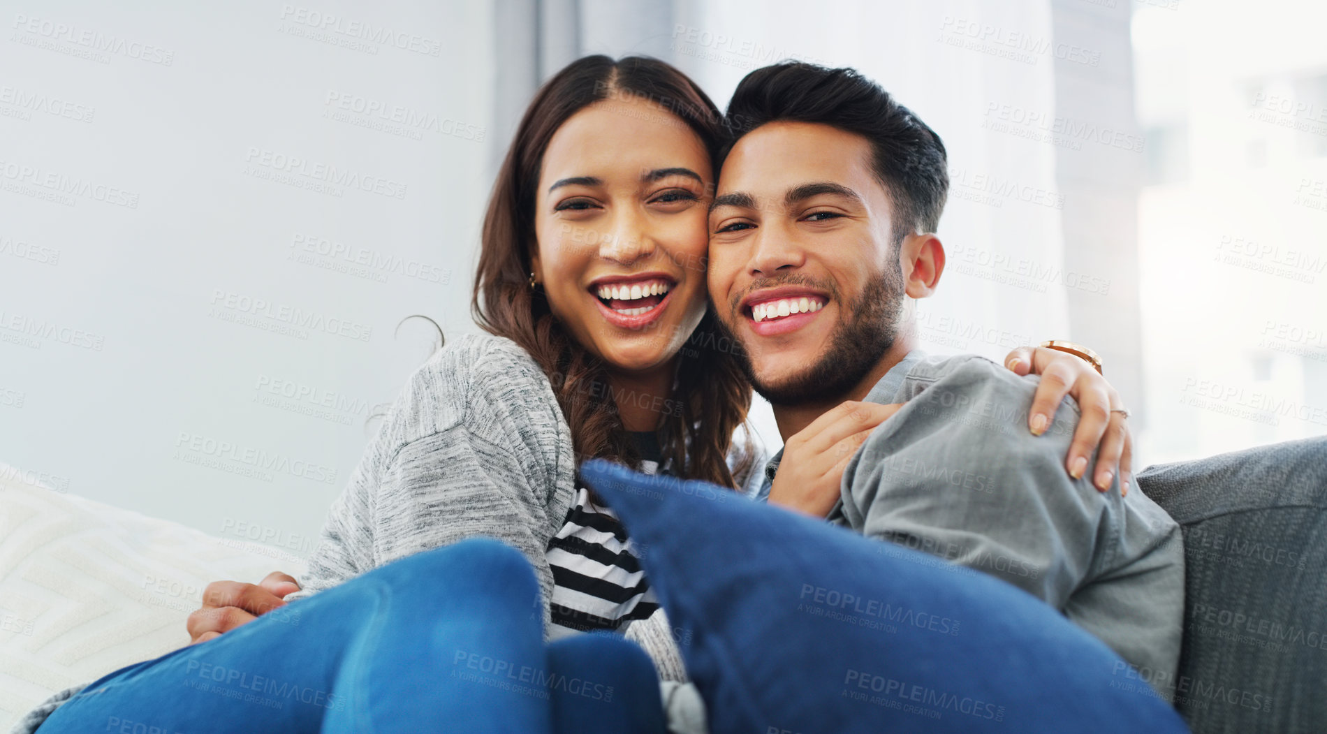 Buy stock photo Cropped portrait of an affectionate young couple holding each other while in their living room during the day