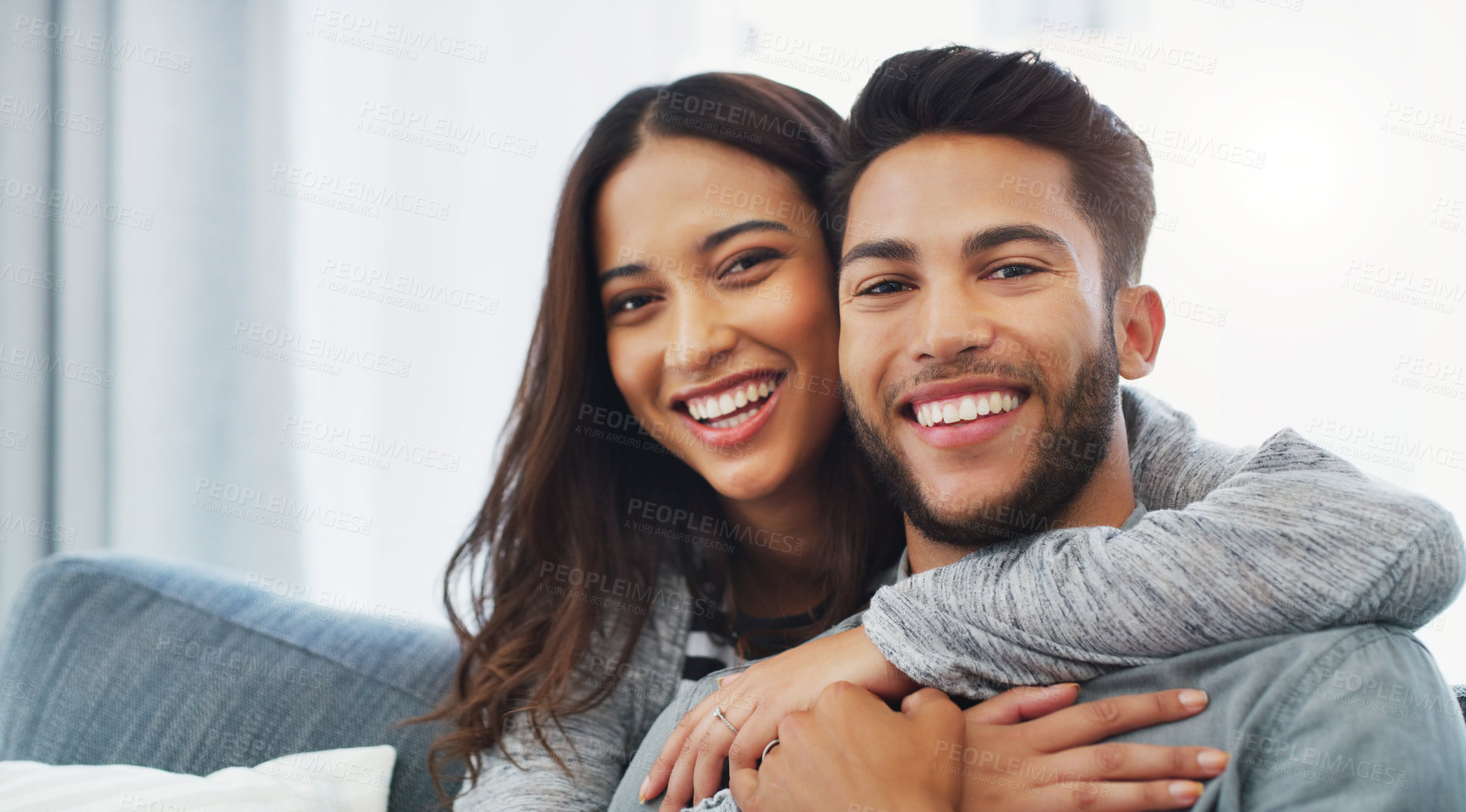 Buy stock photo Cropped portrait of an affectionate young couple holding each other while in their living room during the day