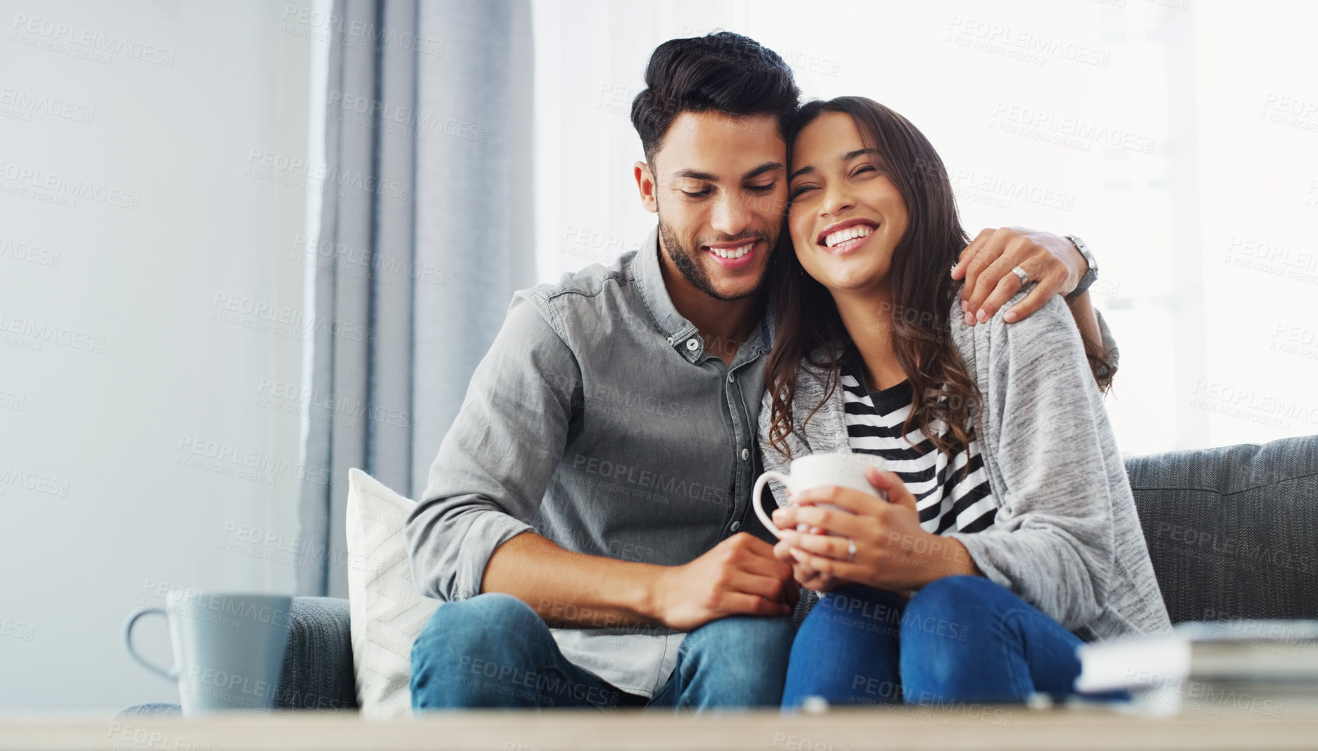 Buy stock photo Cropped shot of an affectionate young couple holding each other while in their living room during the day